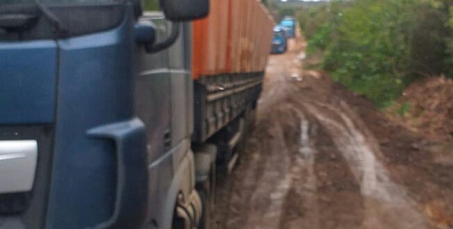 Carreta atola em rua cheia de crateras