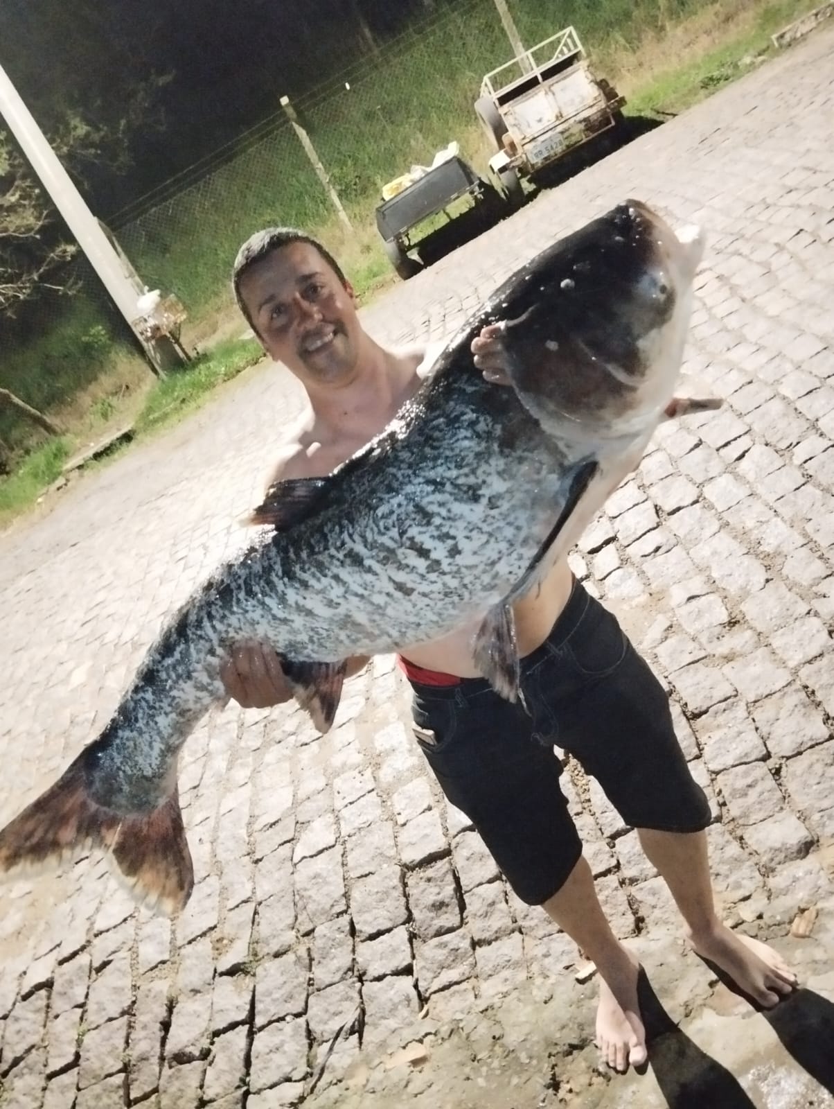 Pescador Rodrigo Barbosa mostra com orgulho a carpa cabeçuda de 28 quilos capturada no Rio Jacuí