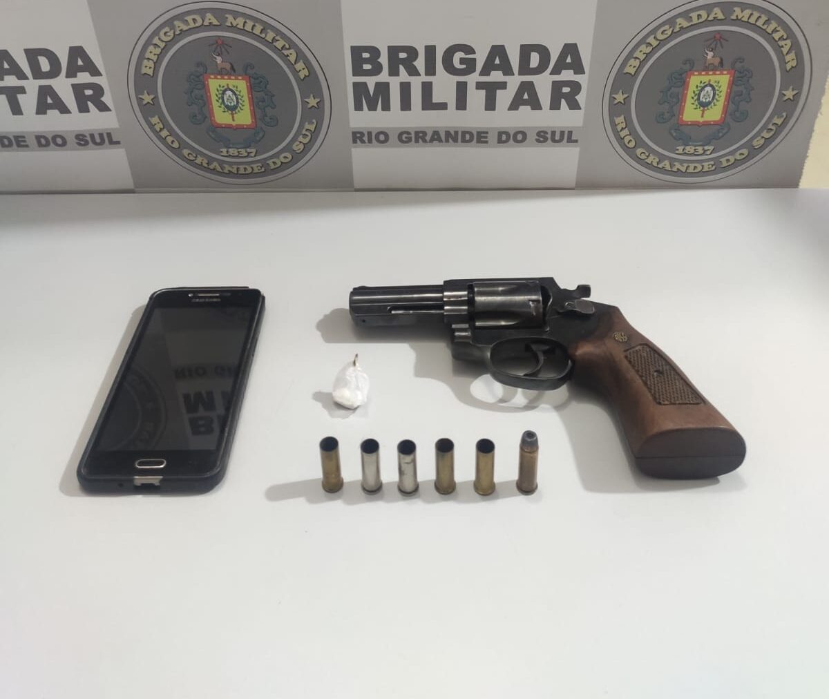 Arma, munição, celular e droga foram apreendidos pela BM após homem ser socorrido e levado ao HCB, onde foi constatado o óbito / Foto: Divulgação