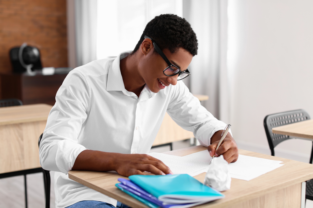 Menino sentando usando óculos e estudando 