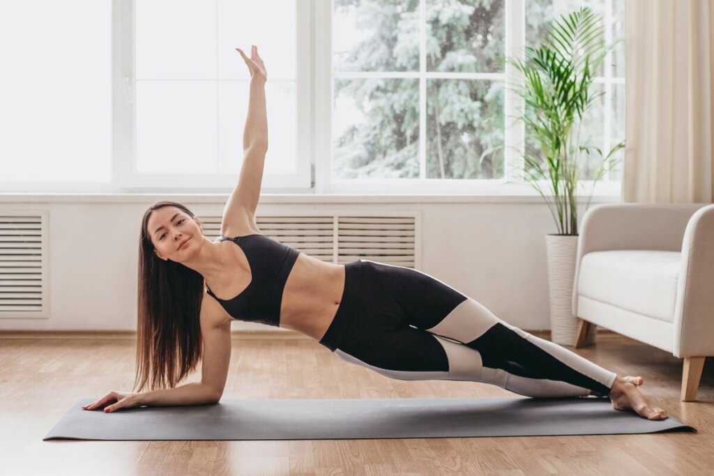 Mulher em uma sala de estar fazendo exercício físico