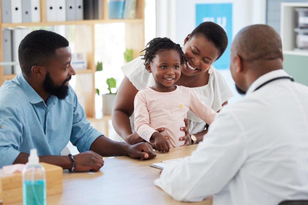 Criança com os pais em consultório do pediatra