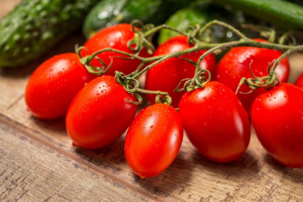 tomates lavados em cima de uma mesa de madeira