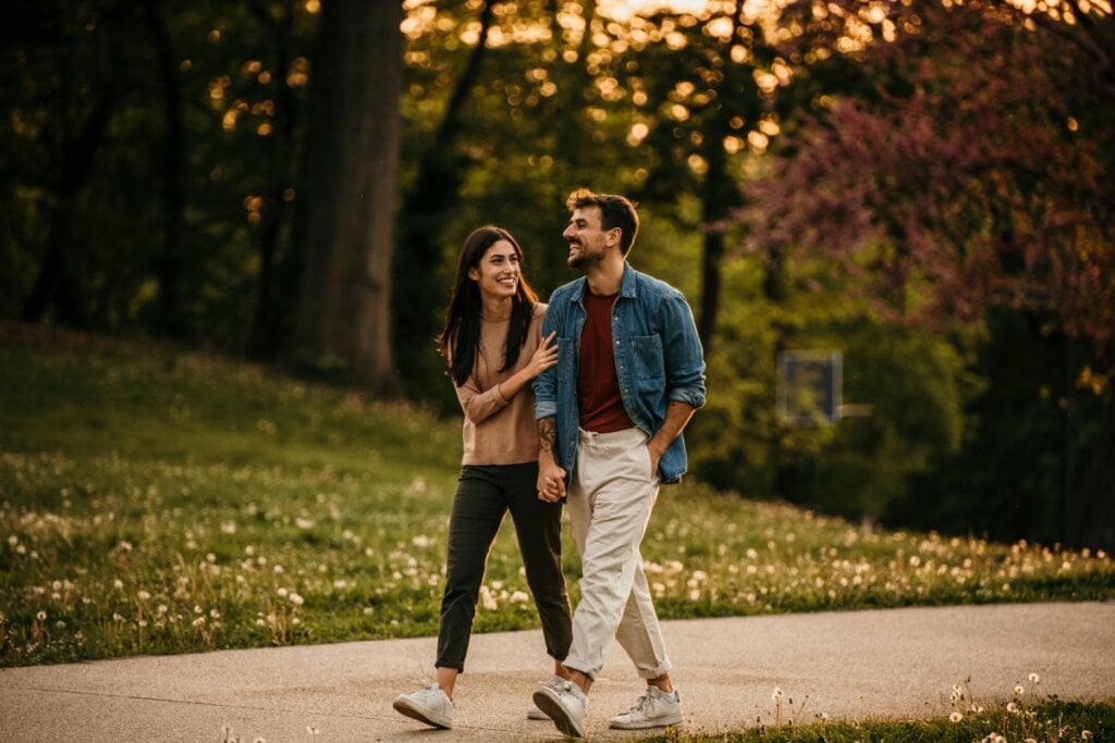 Homem e mulher andando de mãos dadas e sorrindo