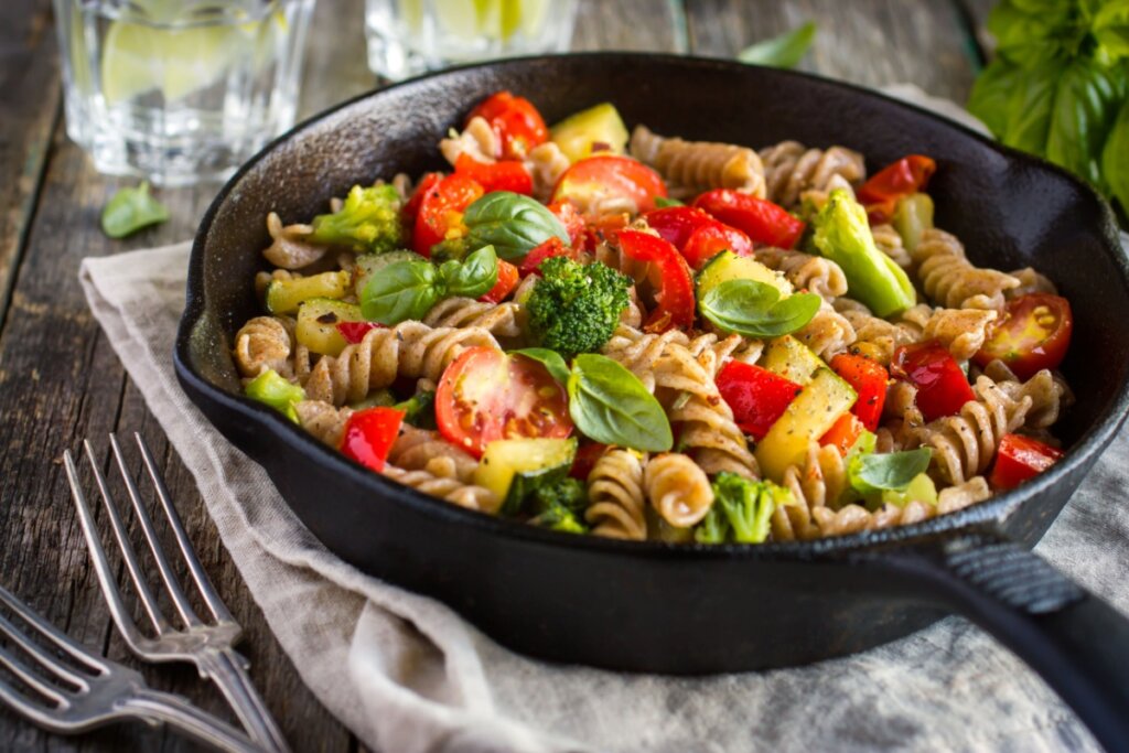 Macarrão com tomate e abobrinha servido em panela de ferro preta