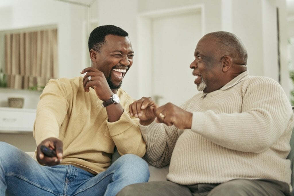 Dois homens sentados sorrindo 