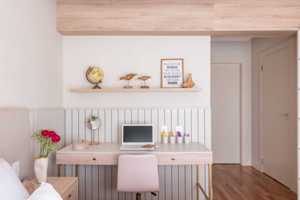 Espaço de home office adequado em uma mesa dentro do quarto com decoração em rosa claro