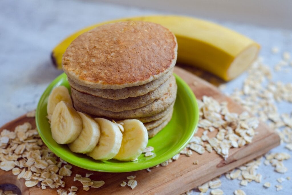 Panqueca de aveia e banana servida em prato de cerâmica verde