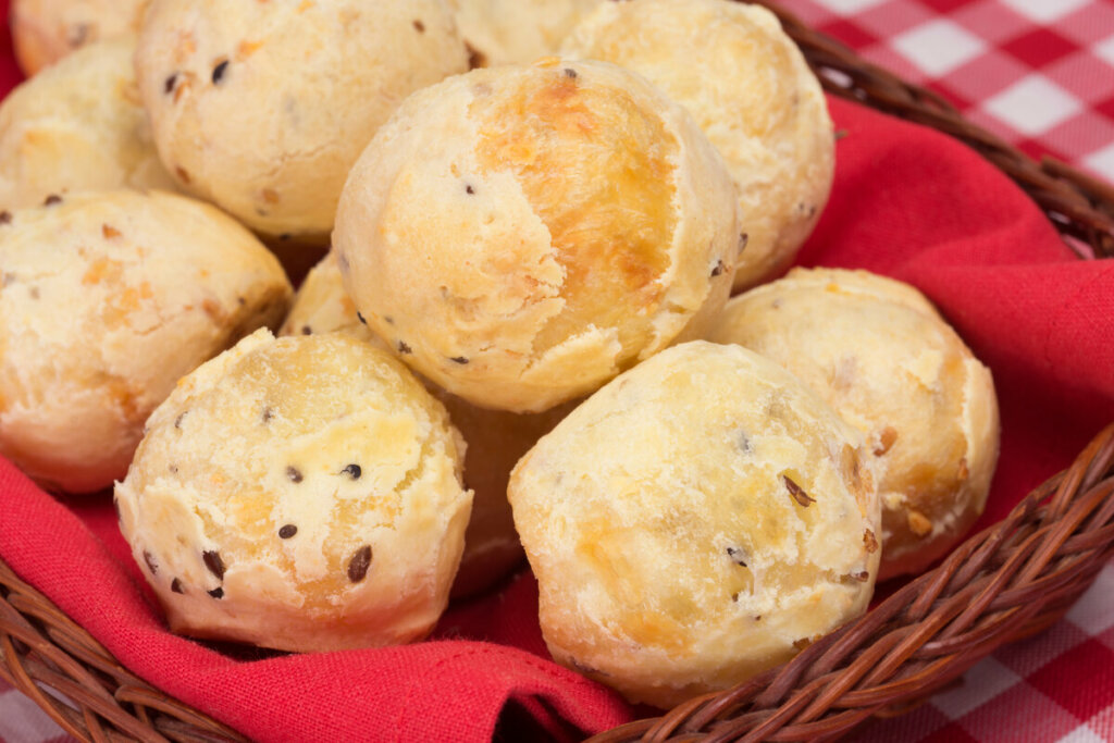 Pães de queijo com chia dentro de uma cesta com pano vermelho