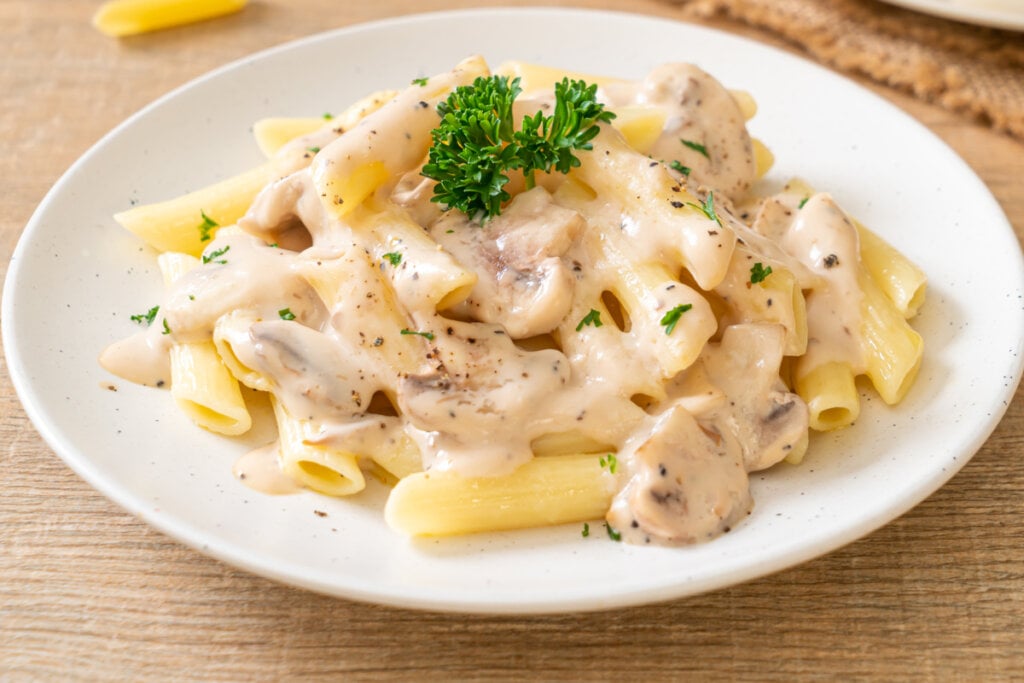 Penne ao molho de cogumelos em prato branco