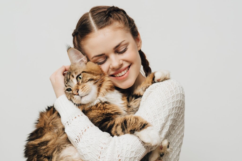 Tutora abraçada com gato maine coon