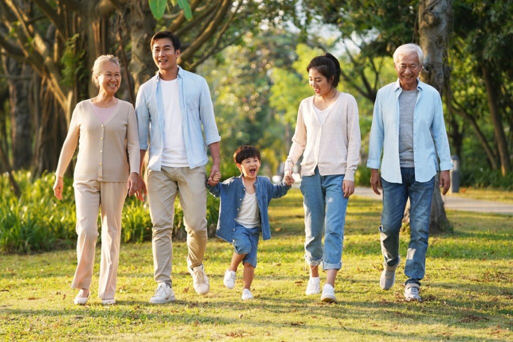 Dois casais passeando com uma criança em um parque 